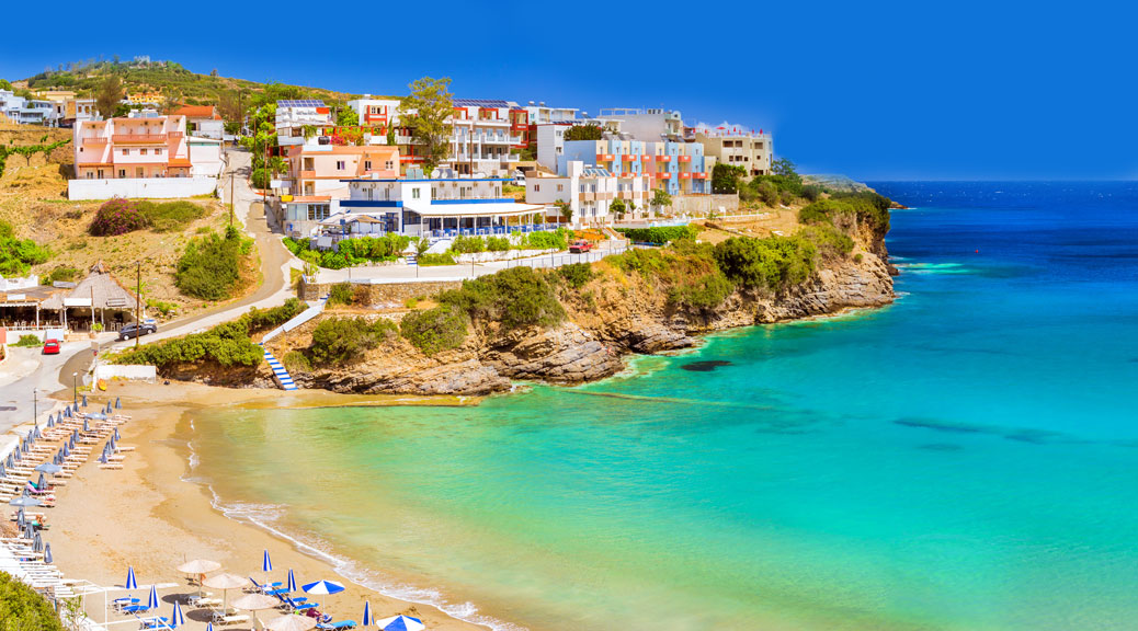 Sun loungers and parasols on the rocky shore. Crete