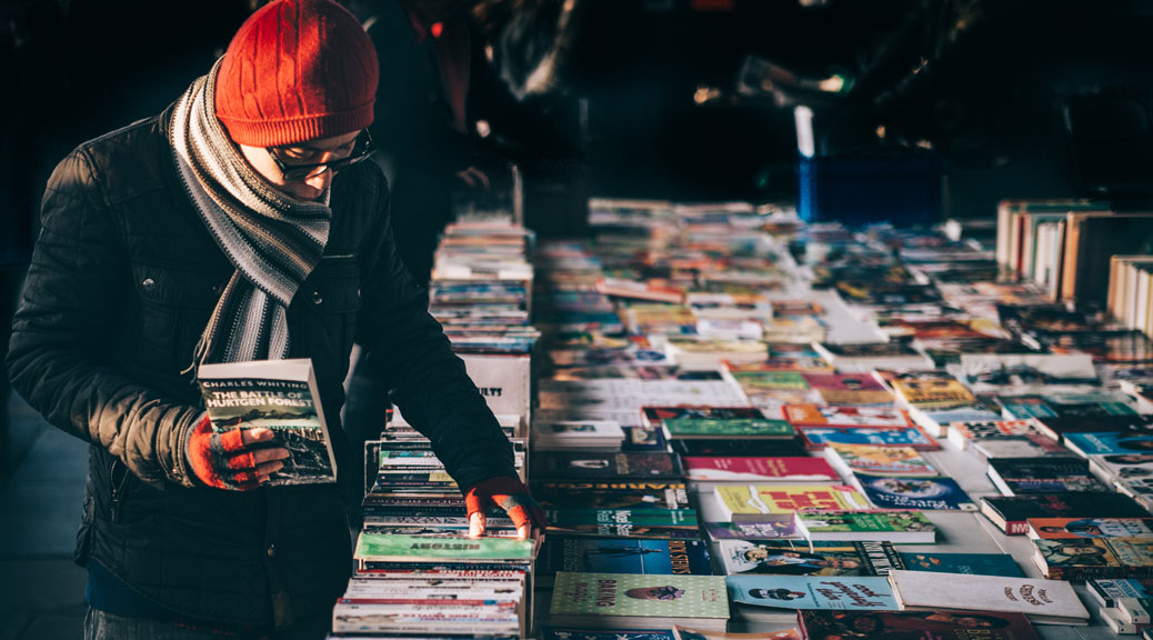 An old man looking at Travel books for planning a vacation