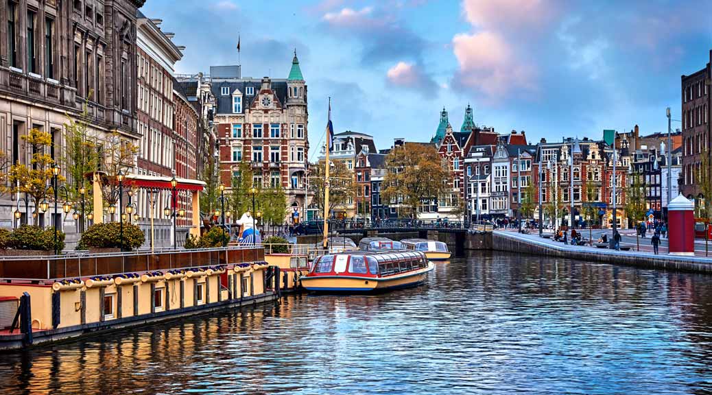 Channel in Amsterdam Netherlands houses river Amstel landmark old European city.