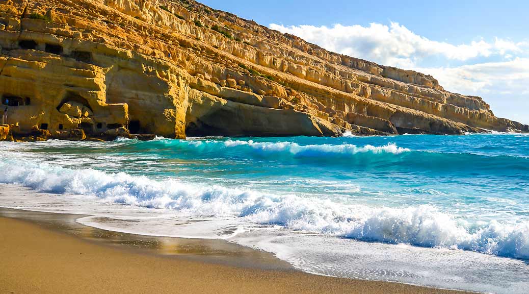 Mountain beach with blue sea water on Matala village, Crete island.