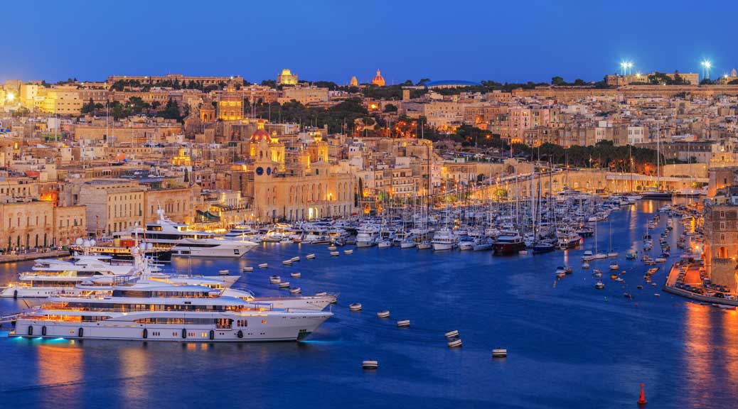 View of Grand Harbor from Upper Barrakka Gardens at sunset Valetta Malta