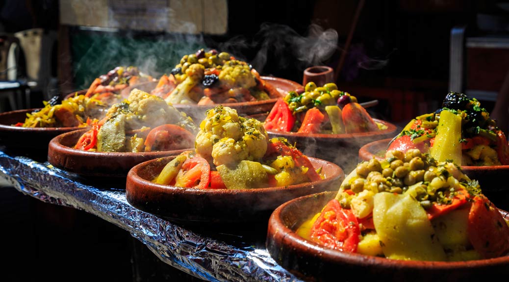 A lot of warm tagines with delicious vegetables on a market