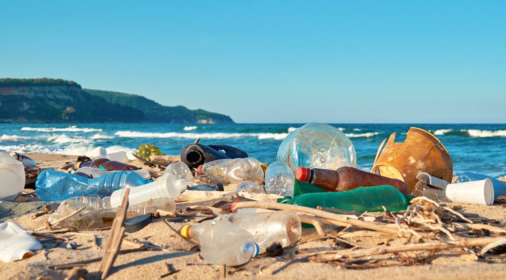 Spilled garbage on the beach empty used dirty plastic bottles